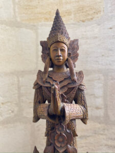Statue en bois sculptée ramenée de nos voyages en Thailande, représentant une figure asiatique traditionnelle, gardien de la maison contre les mauvais esprits, dans l’entrée du Château Papounan, chambre d’hôtes de charme à Saint-Estèphe, Médoc.